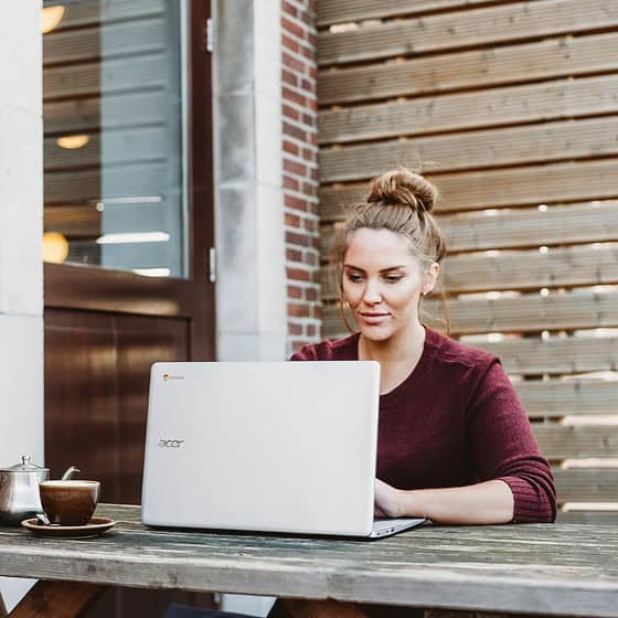 a woman sitting at a table with a laptop