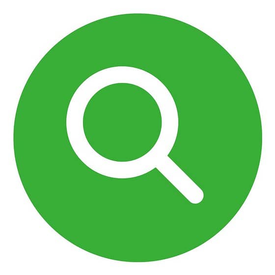 a green circle with a white magnifying glass